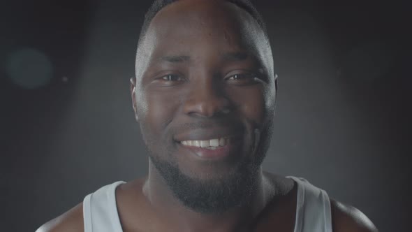 Portrait of Smiling Black Man against Dark Background