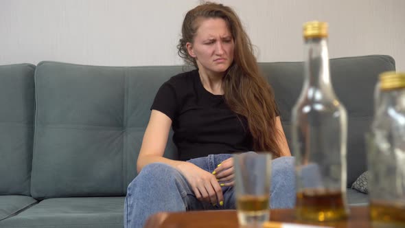 drunk woman after violent drinking session, with empty bottles, glasses