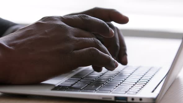 Closeup Black Male Hands Typing on Laptop Keyboard at Office Table