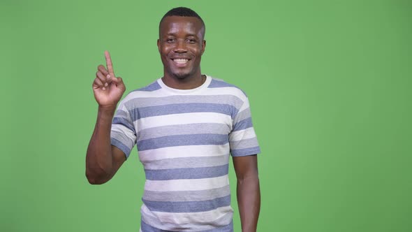 Young Happy African Man Smiling While Pointing Finger Up