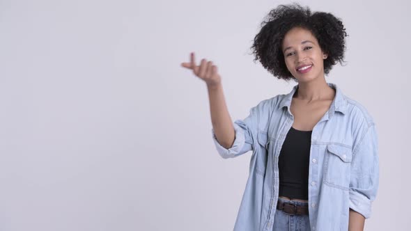 Happy Young Beautiful African Woman Snapping Fingers and Showing Something