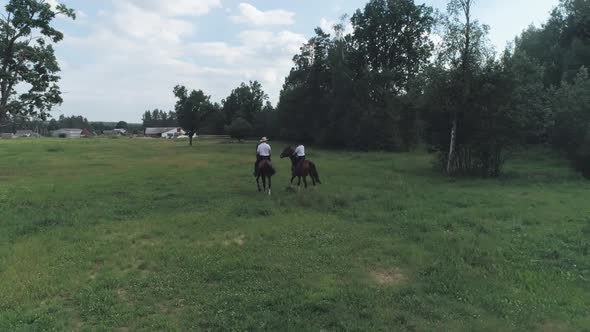 Family Outdoor Recreation Man Cowboy and a Woman Riding a Horse in a Clearing Near the Forest View