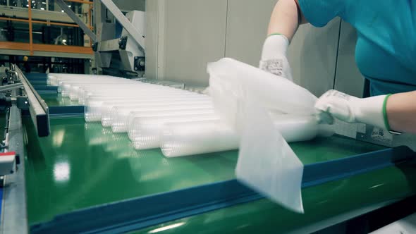 Factory Worker Is Putting Plastic Cups Into Polyethylene Bags