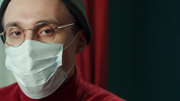 Closeup Face of Young Man in Protective Mask Wearing Glasses Hat