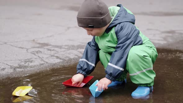 Funny Kid in Rain Boots Playing in a Rain Park