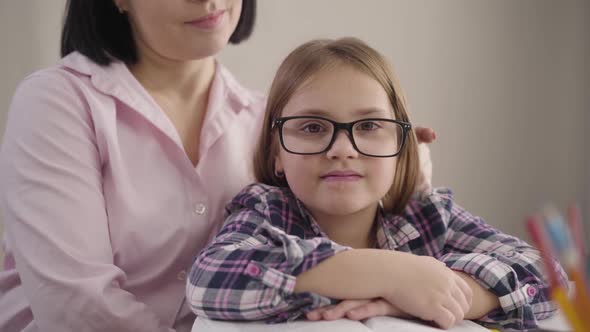 Close-up Portrait of Happy Caucasian Girl in Eyeglasses Looking at Camera and Smiling. Young Mother