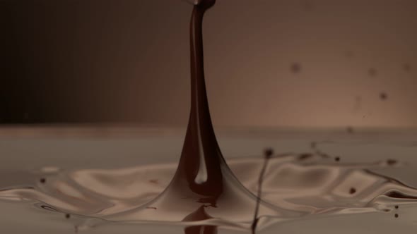 Super Slow Motion Detail Shot of Melted Chocolate Crown Splash on Brown Background at 1000 Fps