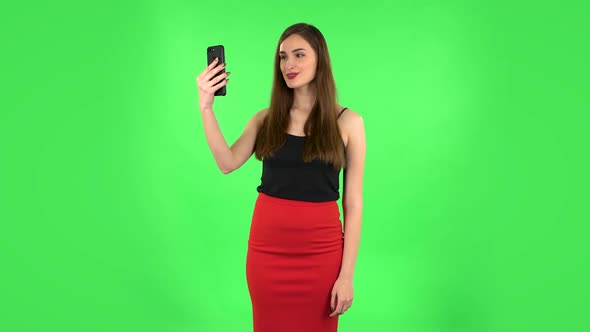 Smiling Girl Talking for Video Chat Using Mobile Phone and Rejoice on Green Screen