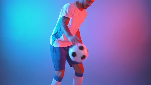 Side Profile View of Freestyle Soccer Player Juggling Ball with His Legs and Knees