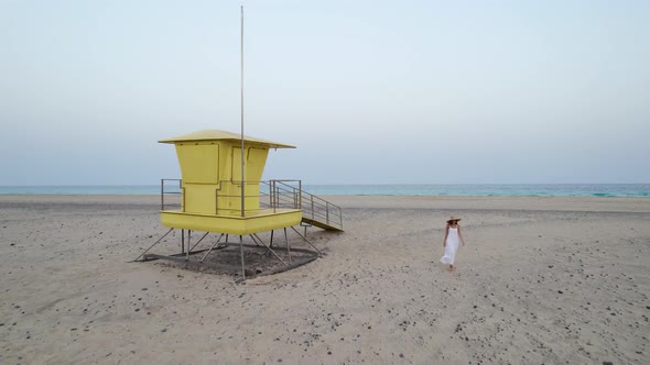 Woman walking near lifeguard hut from drone view