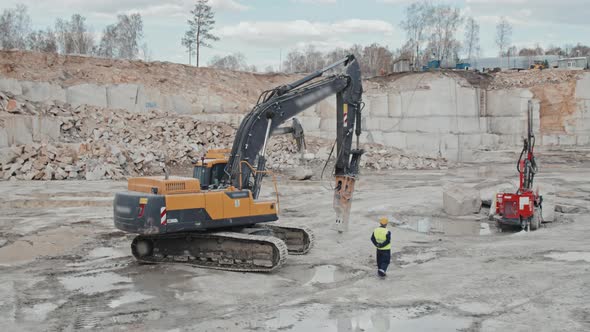 Worker and Heavy Machinery in Granite Quarry