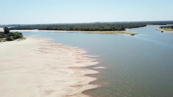 Drone descending over a river in dry season on a sunny day.