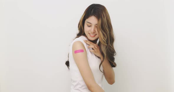 Smiling Asian Woman Shows Bandage On Arm.