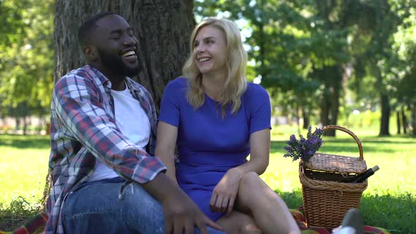Afro-American Man Whispering Rumors in Womans Ear and Laughing, Having Fun