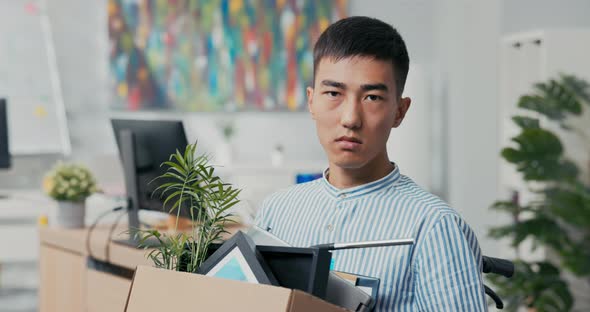 Disabled Ambitious Man in Shirt with Asian Korean Beauty Sits in Wheelchair at Desk in the Company