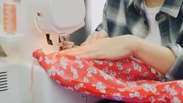 Close up of woman's hands working on overlock. Sewing concept