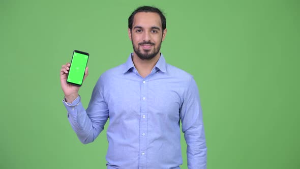 Young Happy Bearded Indian Businessman Showing Phone and Giving Thumbs Up