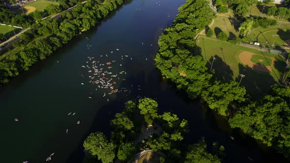 Aerial view of a group of SUP boarders on the Colorado river with Austin skyline in the background -