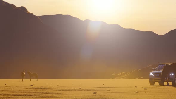 White Luxury Off-Road Vehicle Coming from Horses in Mountainous Area with Sunset View