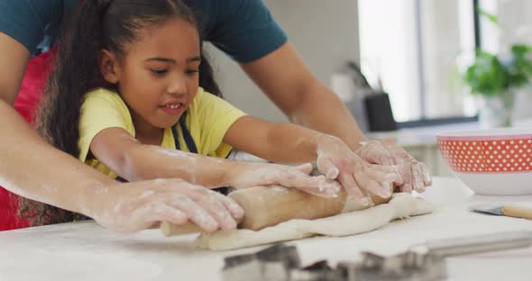 Happy biracial father and daughter baking together in kitchen