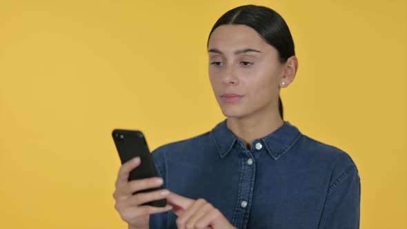 Latin Woman Using Smartphone Yellow Background