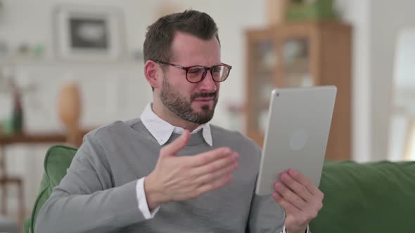 Middle Aged Man Reacting to Loss on Tablet