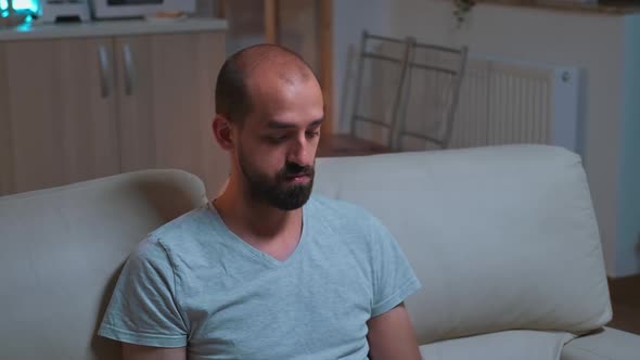 Tired Man Sitting in Front of Television Writing Lifestyle Information