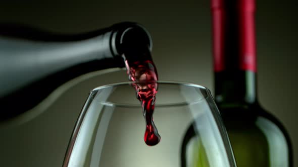 Super Slow Motion Detail Shot of Pouring Red Wine From Bottle on Luxury Grey Background at 1000Fps