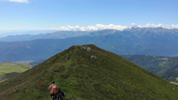 Aerial Slow Motion: Couple Backpackers Hiking on Mountain Top, Scenic Landscape