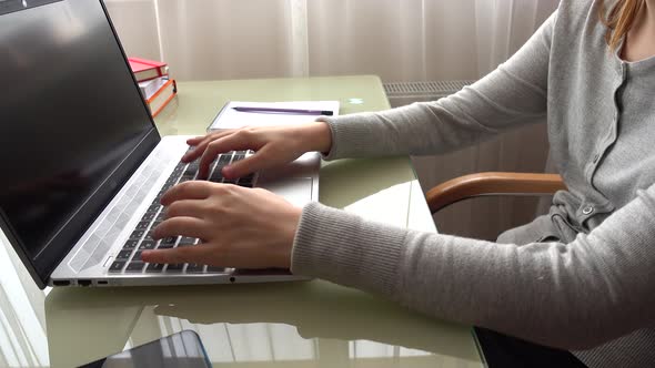 The girl working at home office hands on keyboard.