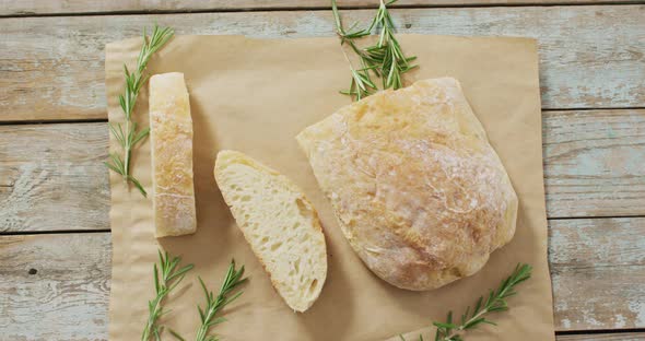 Video of rosemary and brad on baking paper on wooden worktop