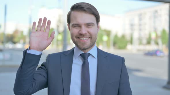 Welcoming Businessman Waving Hand for Hello Outdoor