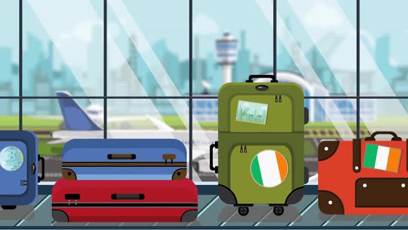 Suitcases with Irish Flag Stickers on Baggage Carousel in Airport