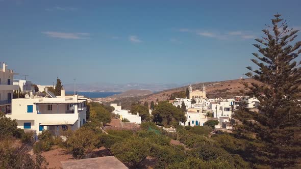 Aerial Drone Shot Pulling Back from the Village of Lefkes Greece Revealing some Trees in the Foregro