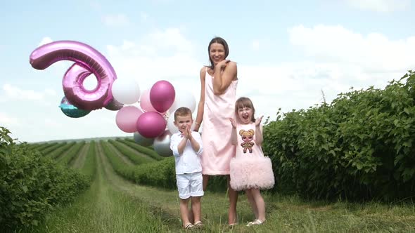 Happy Mother and Her Little Daughter and Son in the Summer Field Happy Family