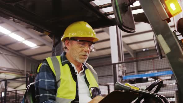 Worker examining while writing on clipboard