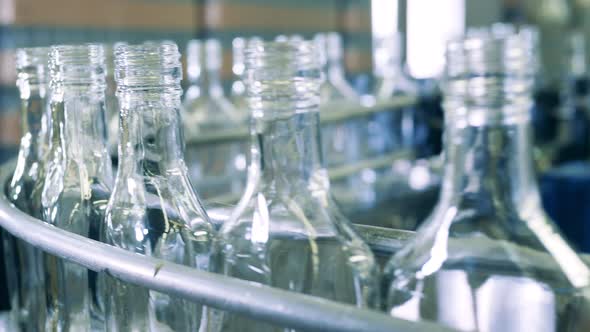 Close Up of Glass Bottles Moving Along the Conveyor Belt