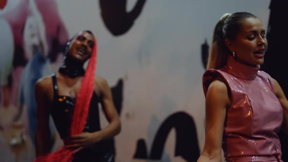 Young Woman And Man In Pvc Clubwear Walking Singing And Posing