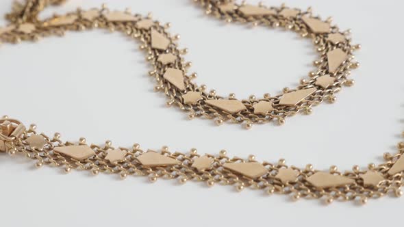 Luxurious golden necklace chain on white 4K  panning video