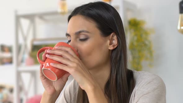 Woman Enjoying Warm Beverage in Cozy Home Atmosphere, Relaxation and Harmony