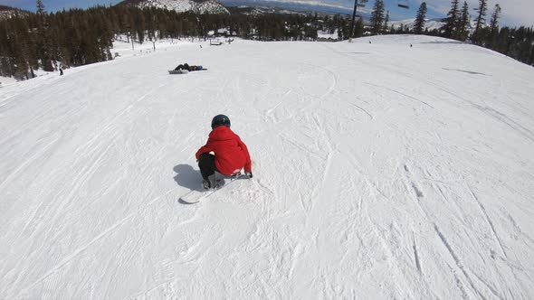 A boy snowboarder snowboarding at a ski resort.