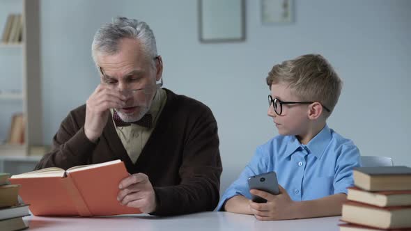 Grandfather Teaching His Grandson About Dangers of Mobile Phone, Generation Gap