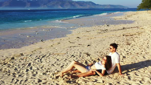 A Couple Romantically Spending The Afternoon On The Beautiful, Quite Beach Of Hawaii Admiring The Sc