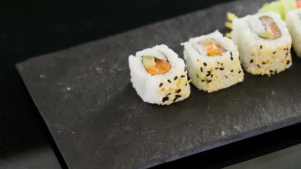 Uramaki sushi served on grey stone slate