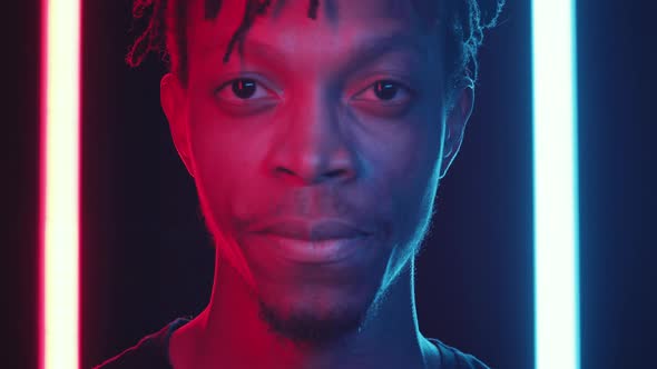 Handsome African American Man Smiling at Camera in Neon Light