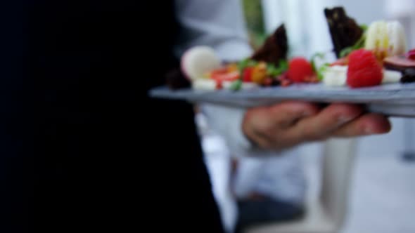 Mid section of waiter holding food tray