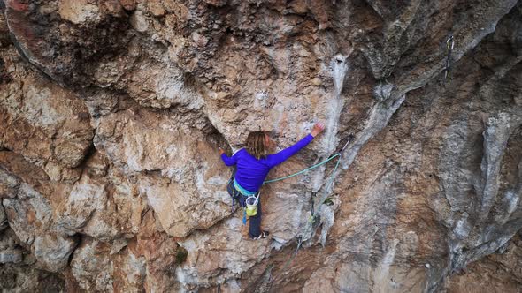 Strong Girl Rock Climber Climbs on Overhanging Crag