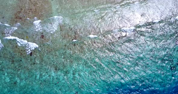 Tropical birds eye travel shot of a white sandy paradise beach and aqua blue water background in col