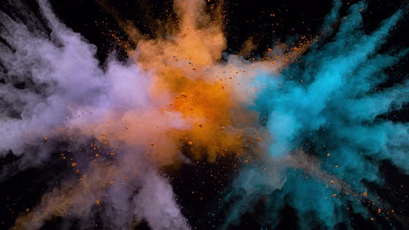 Colorful powder/particles fly after being exploded against black background. Slow Motion. alt