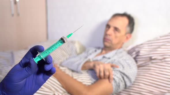 Syringe with Medicine on the Background of a Sick Senior